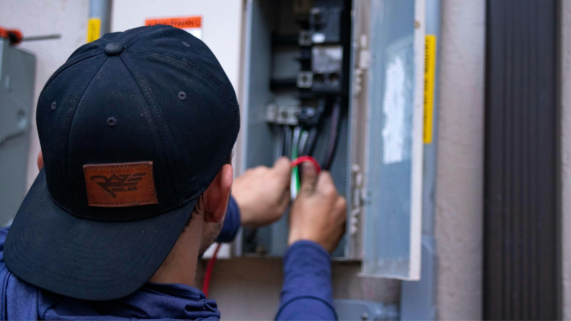 Commercial Electrician inspecting security breaker