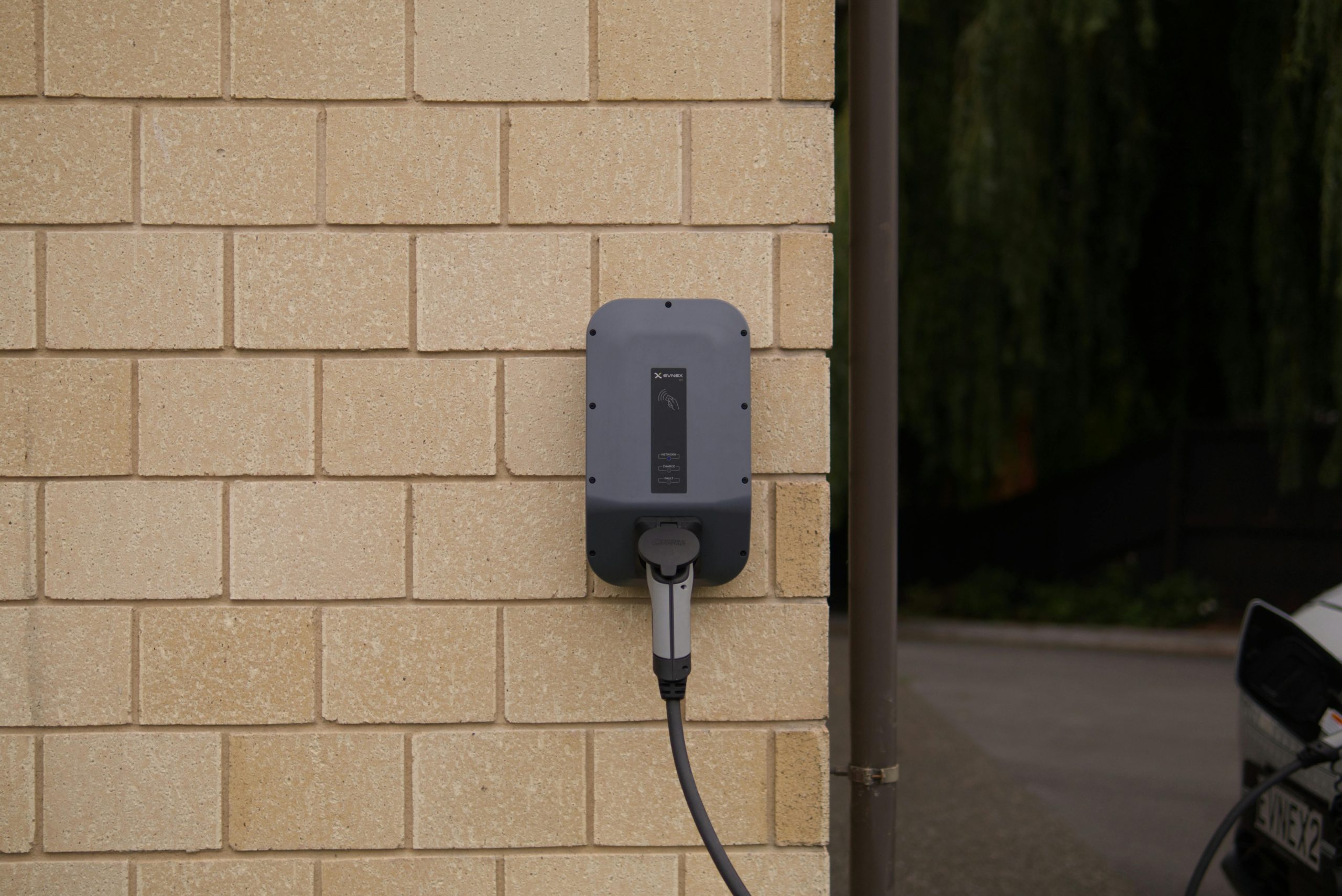 Wall mounted home EV charger installed on exterior brick wall